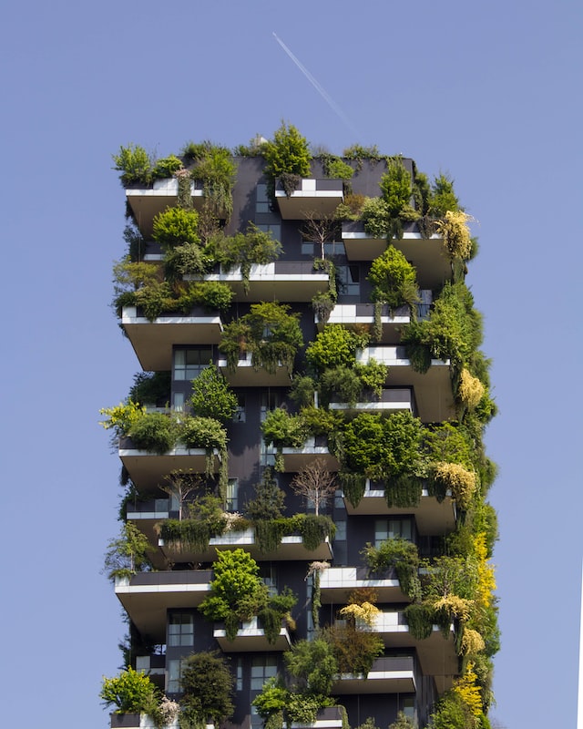 image of outside of a block of flats with covered with a lot of green plants. the flat has sevral floors
