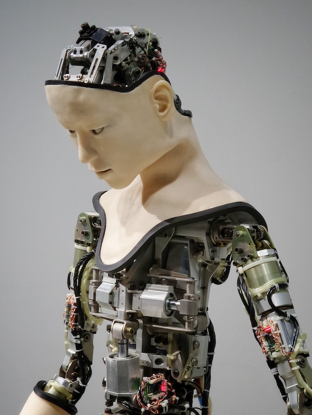 image of a robot desgined as a human. face and neck is human-mask, rest of body is electronoic parts